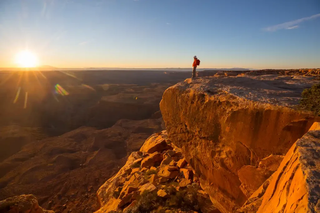 Mann guckt von einer Klippe auf das Tal